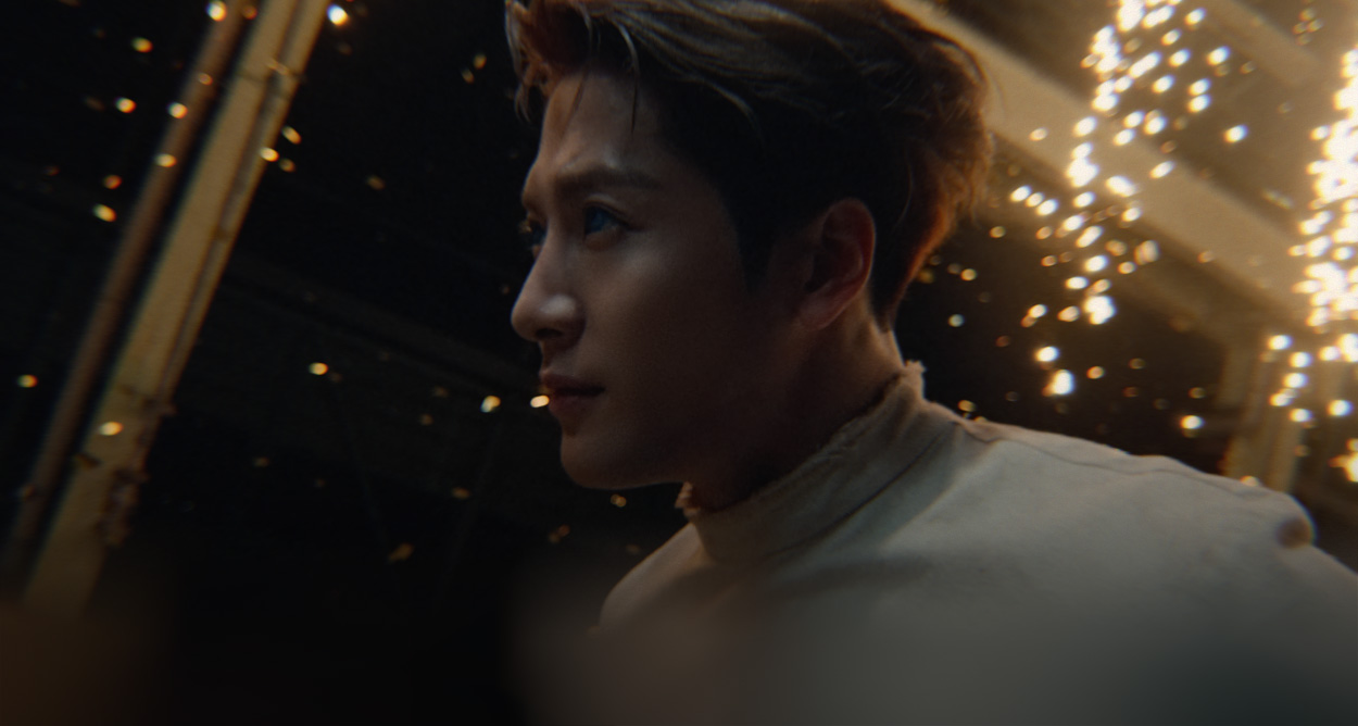 Close-up side profile view of Jackson Wang with sparklers and confetti in the background